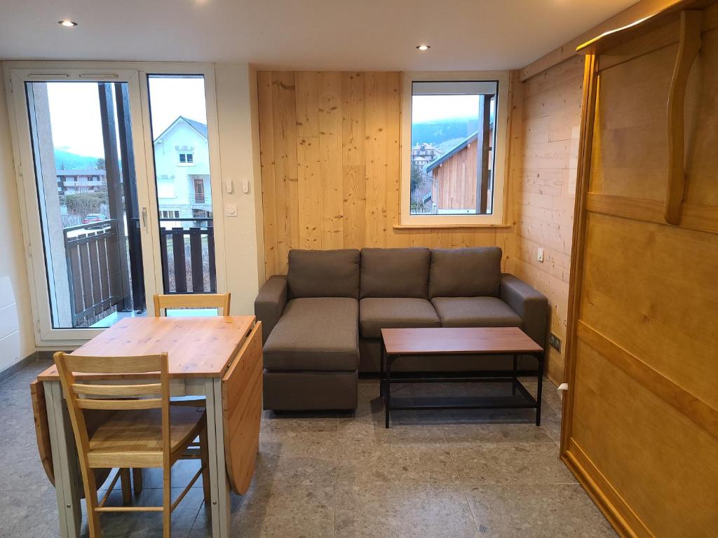 ein Wohnzimmer mit einem Sofa und einem Tisch in der Unterkunft Résidence Croix Margot in Villard-de-Lans