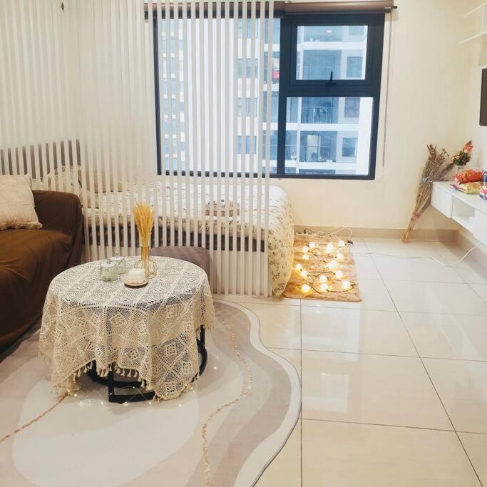 a living room with a table and a couch at Homestay Vinhome Ocean Park S201 in Hanoi