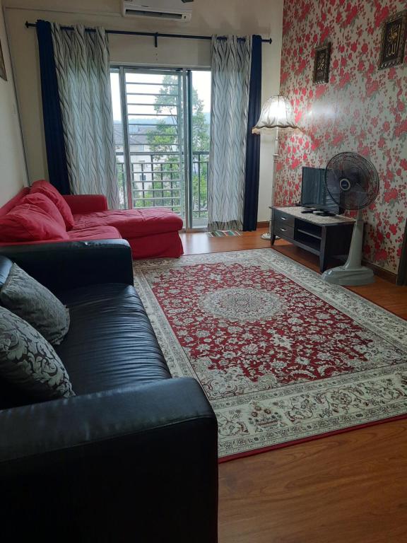 uma sala de estar com um sofá e um tapete em Ratu Homestay em Kuala Selangor