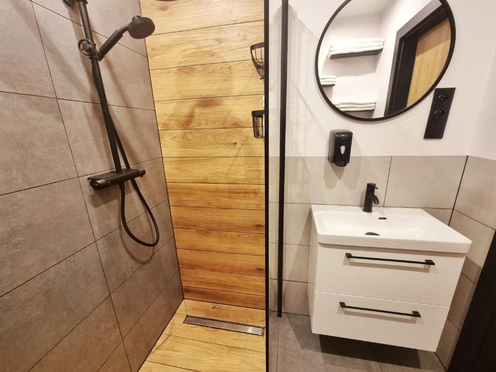 a bathroom with a shower and a sink and a mirror at Na Szczycie in Chełm