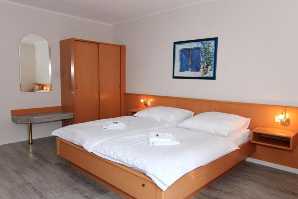 een slaapkamer met een groot bed met twee dienbladen erop bij Hotel Messeblick in Sarstedt