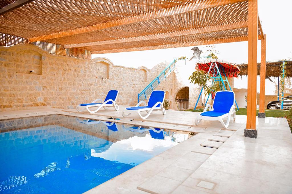 una piscina con sillas azules y un tobogán en كمبوند قرية تونس, en Tunis
