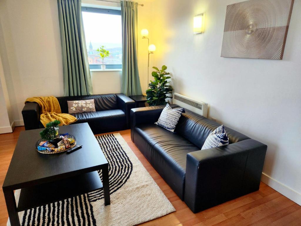 Hotel Home2Home 2 bedroom & 2 bathroom central Apartment with FREE PARKING near University and Hospital, a living room with a black leather couch and a table at Home2Home 2 bedroom & 2 bathroom central Apartment with FREE PARKING near University and Hospital in Sheffield
