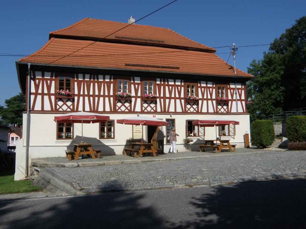 a building with tables and umbrellas in front of it at U Bílého koníka in Kostelní Bříza