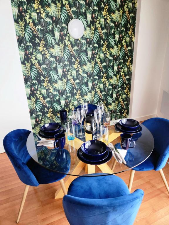 tavolo da pranzo con sedie blu e tavolo con bicchieri di Stylish 2 bed & 2 bath City Centre Apartment with FREE PARKING a Sheffield