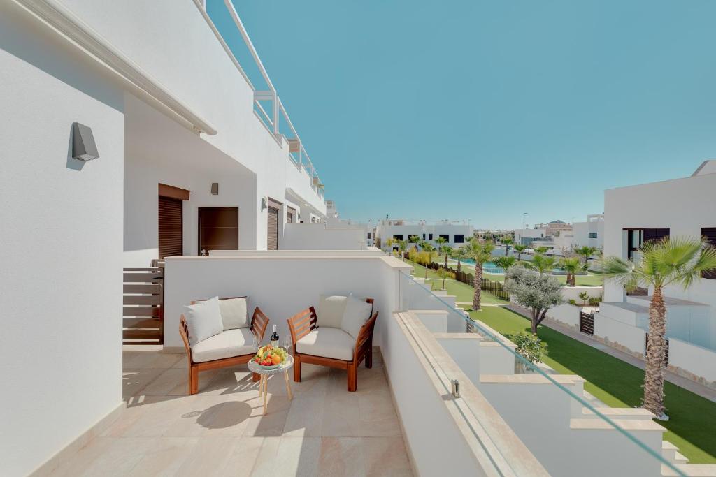 een balkon met stoelen en tafels in een gebouw bij Apartament Porto Marina in Torre de la Horadada