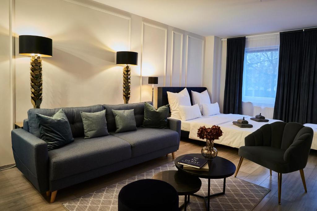 ein Wohnzimmer mit einer Couch und einem Bett in der Unterkunft R B Apartment Hamburg Business am Flughafen für 1-5 Personen - ideal für Geschäftsreisende und Familien - Küche - Waschtrockner - Smart TV - kostenloser Parkplatz in Hamburg