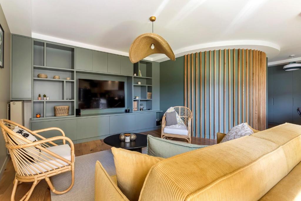 ein Wohnzimmer mit einem Sofa und Stühlen in der Unterkunft Appartement spacieux avec balcon 6pers in Lyon