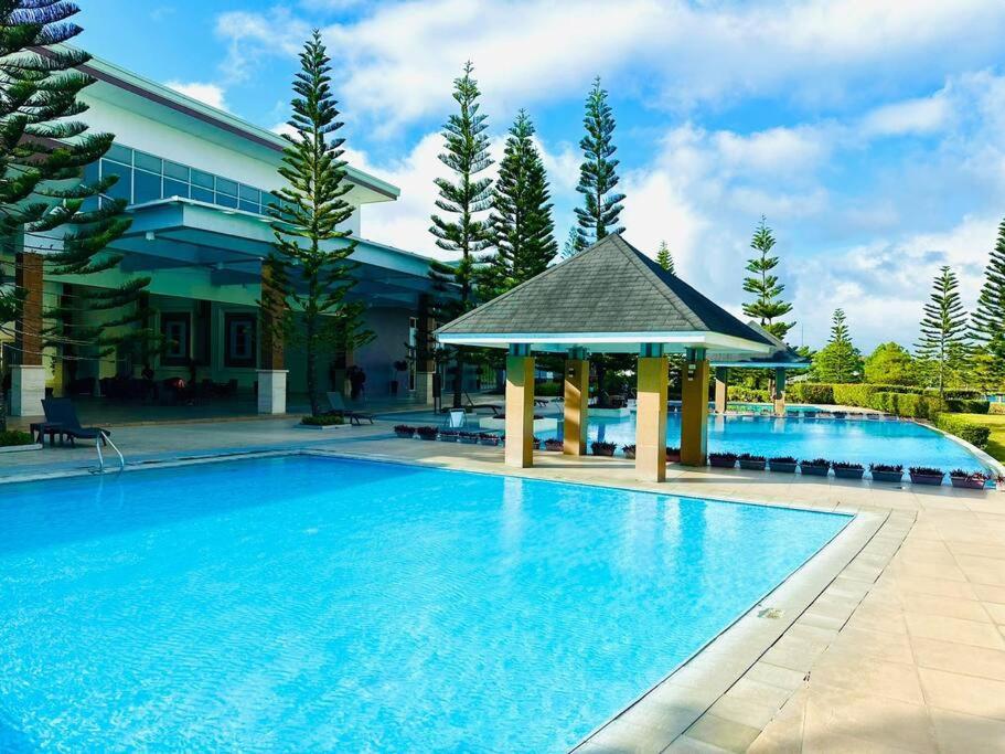 a large swimming pool with a gazebo next to a building at Cool and Savvy 1BR @Cool Suites Tagaytay in Tagaytay