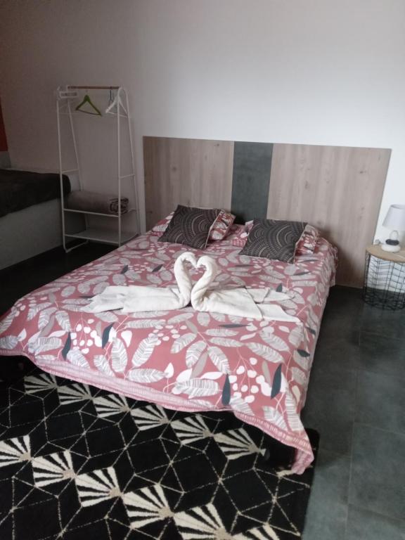 sypialnia z łóżkiem z różowym kocem w obiekcie L'améthyste w mieście Le Tampon