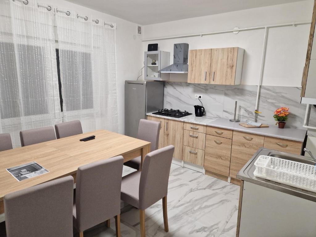 cocina con mesa de madera y sillas en una habitación en Sobe kuća za odmor apartmani Auto Klarić, en Nova Gradiška