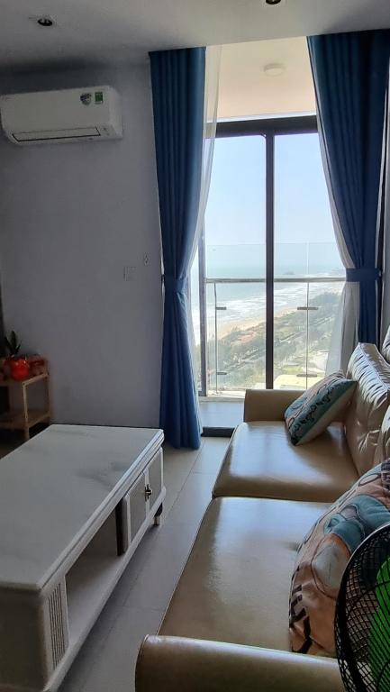 ein Wohnzimmer mit Couch und großem Fenster in der Unterkunft Trinh CSJ Tower 169 Thuỳ Vân in Vũng Tàu