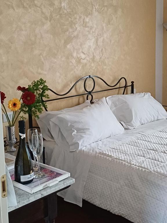 een bed met een dienblad met een fles wijn en glazen bij Aquila Antica in LʼAquila