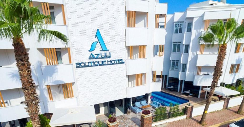 an apartment building with a swimming pool and palm trees at Azuu Boutique Hotel in Antalya