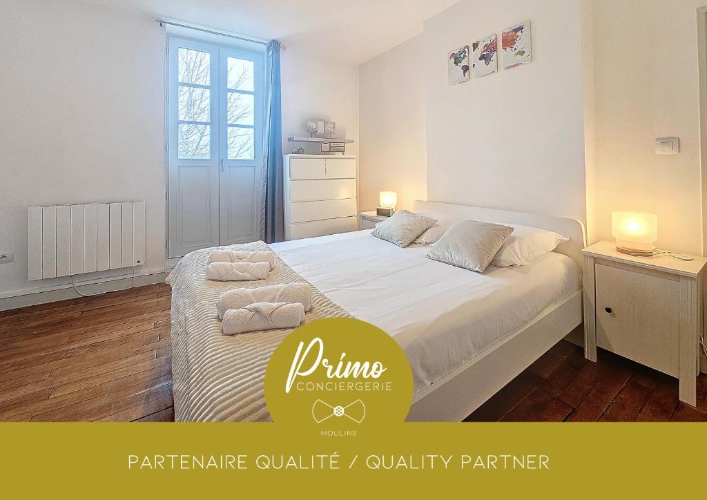 een slaapkamer met een wit bed en 2 handdoeken bij Le Régemortes, centre ville et proche du CNCS, avec services premium by PRIMO C0NCIERGERIE in Moulins