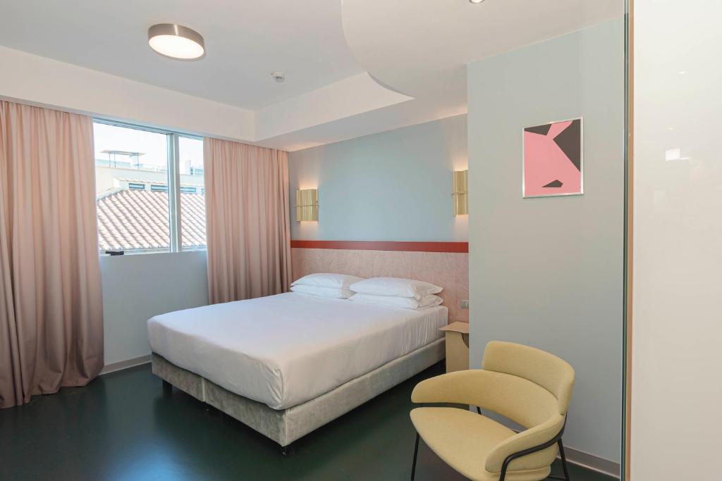 ein Hotelzimmer mit einem Bett und einem Stuhl in der Unterkunft Moderno Hotel Roma in Rom