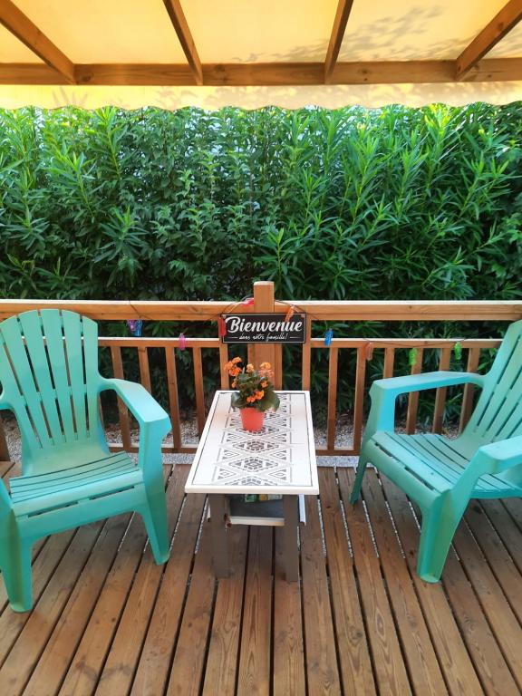 2 chaises et une table sur une terrasse dans l'établissement Mobilhome 8 pers, à Fréjus