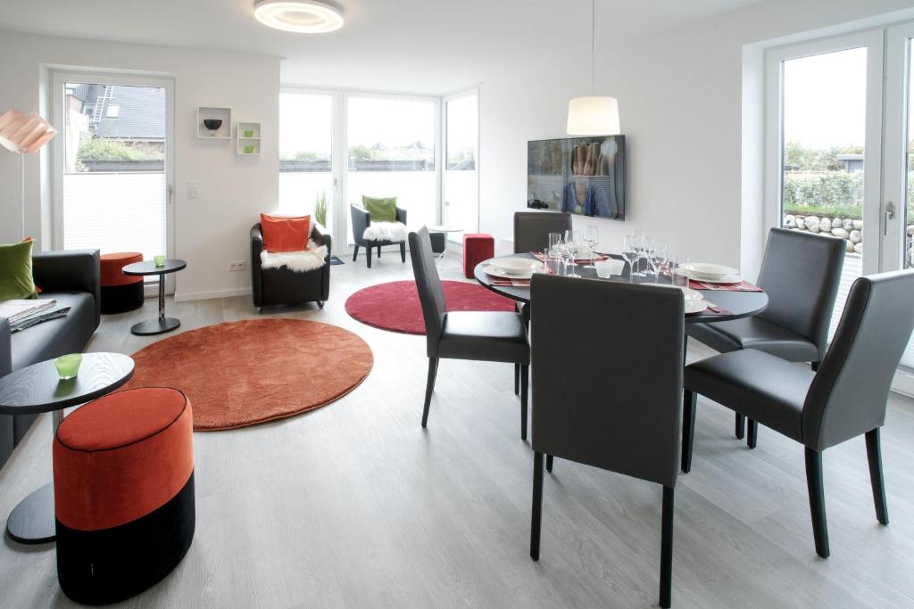 a dining room and living room with a table and chairs at MeerVerliebt C in Hörnum