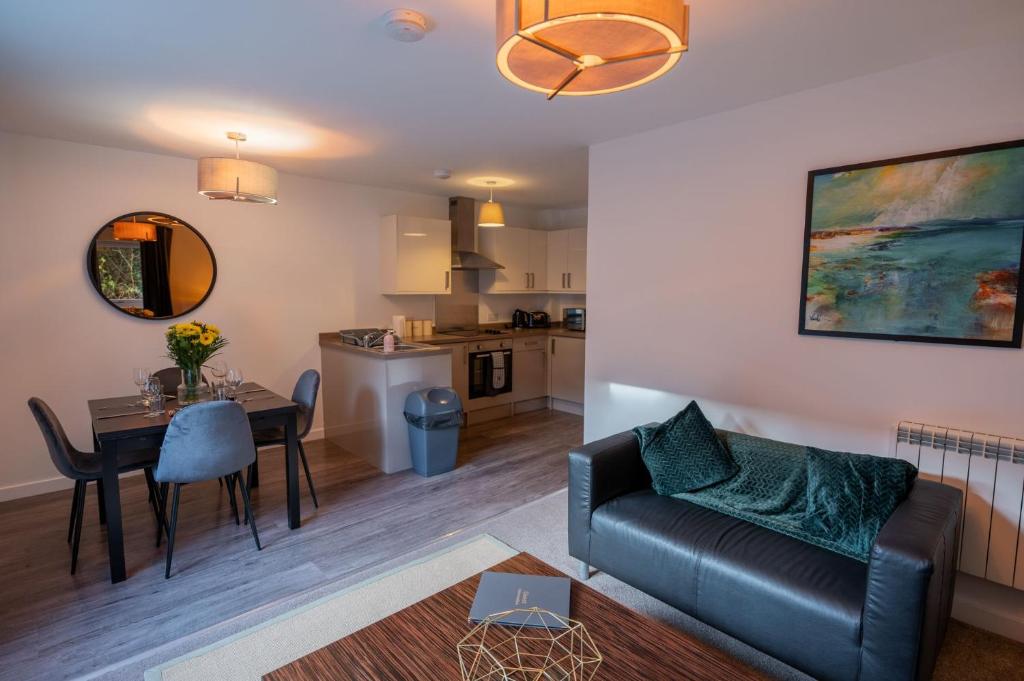 Una sala de estar y una cocina con un sofá y una mesa. en Tobermory Apartment, en Oban