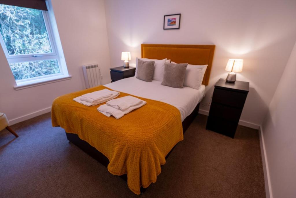 a bedroom with a bed with two towels on it at Tobermory Apartment in Oban