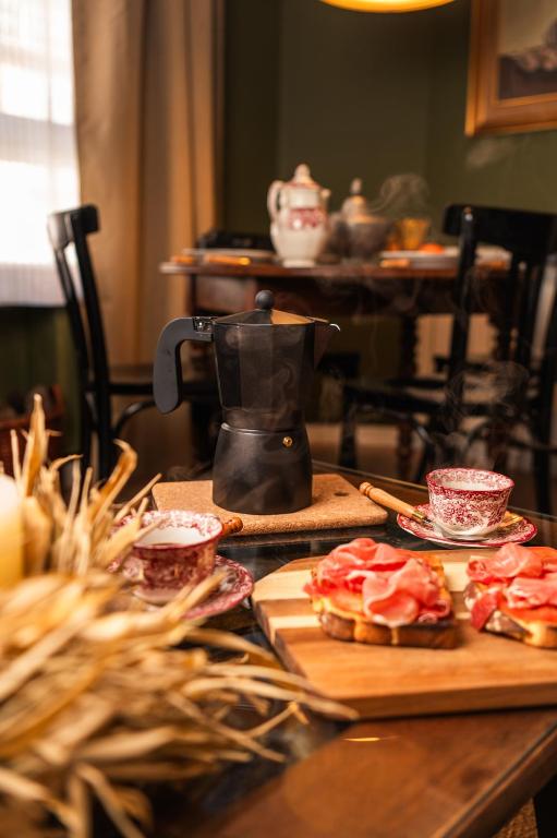 a table with a coffee pot and food on it at Casa Wenceslao in Pola de Laviana