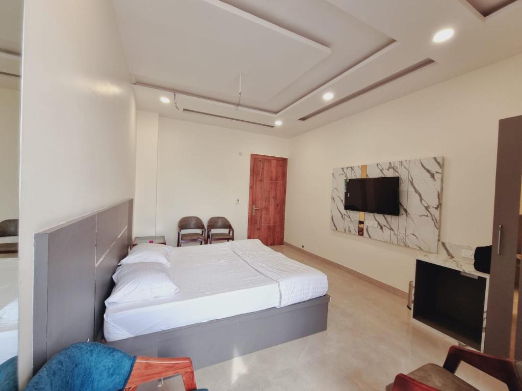 1 dormitorio con 1 cama y TV de pantalla plana en C T Heights Inn, en Bharatpur