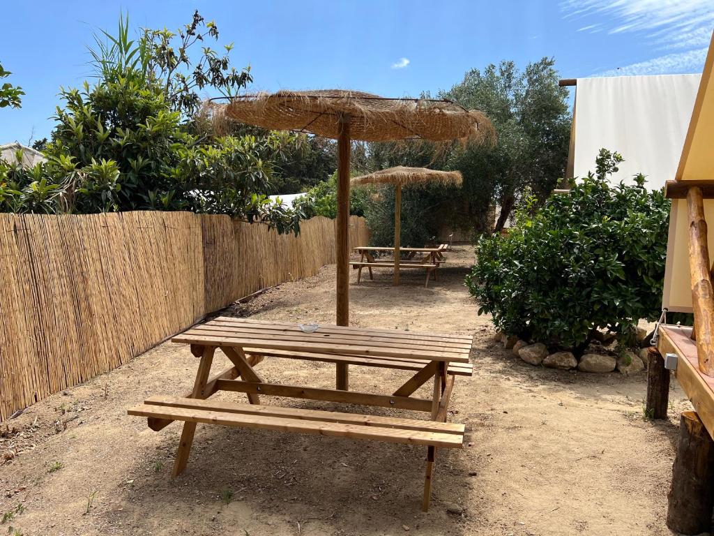 mesa de picnic con sombrilla y 2 bancos en BOHO GLAMPING CONIL, en Cádiz