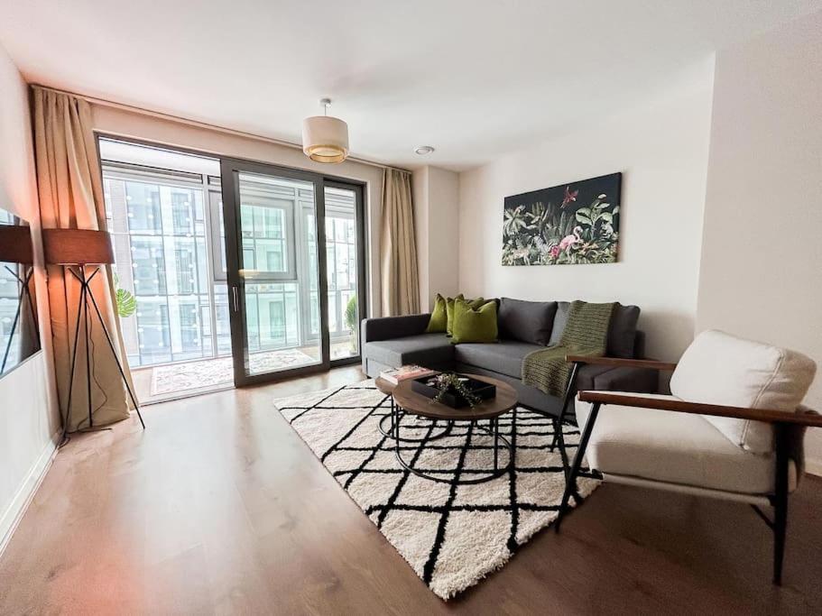 een woonkamer met een bank en een tafel bij Stylish Urban Sanctuary with Parking in Londen