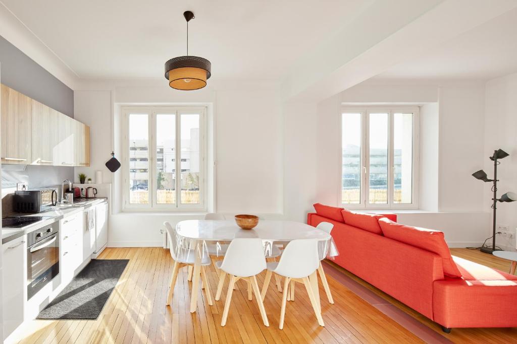 un salon avec un canapé rouge et une table dans l'établissement Charme et confort entre jardin des plantes et LU, à Nantes