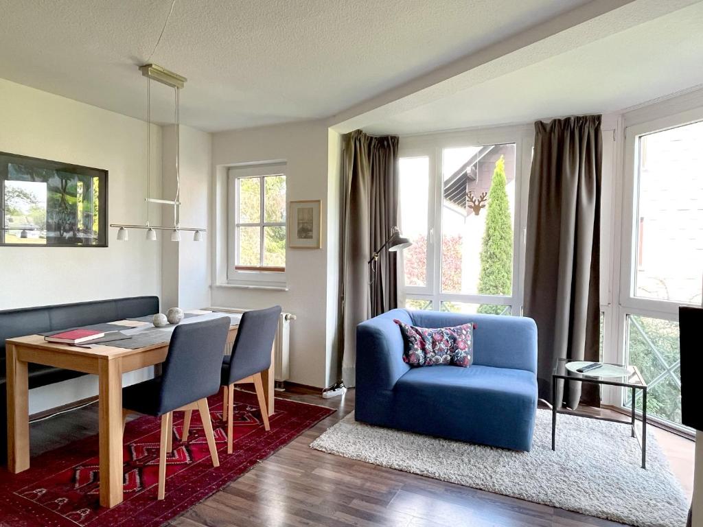 ein Wohnzimmer mit einem blauen Stuhl und einem Tisch in der Unterkunft Apartment Heller am Hasselkopf in Braunlage