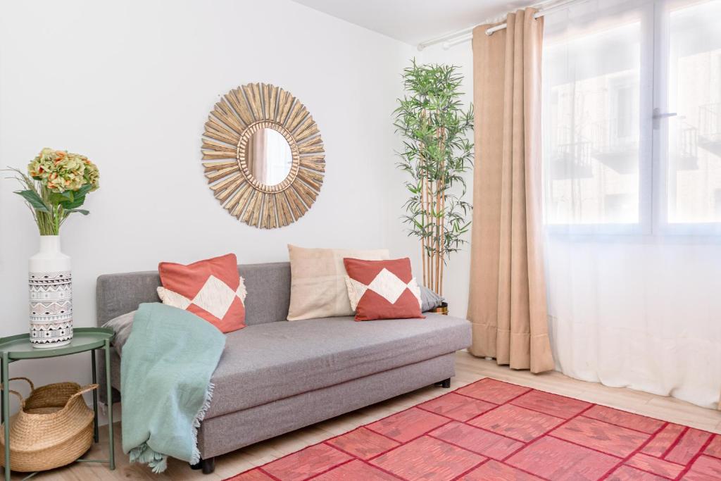 ein Wohnzimmer mit einer Couch und einem Spiegel in der Unterkunft Chueca I calle Farmacia 1BR 1BH in Madrid