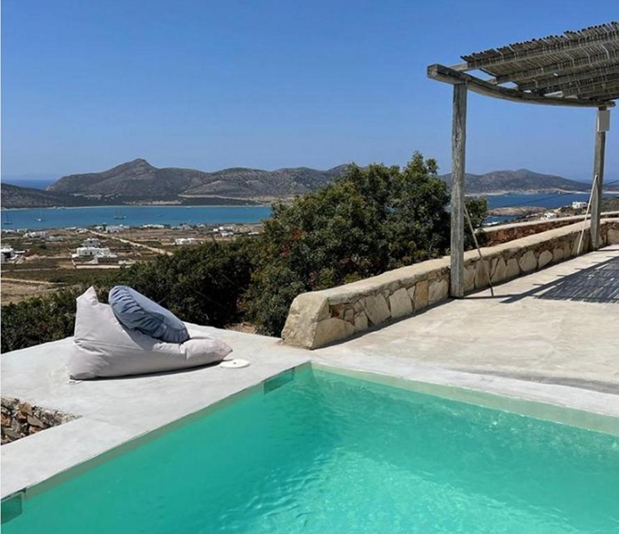 a pillow is sitting next to a swimming pool at Cute Antiparos Villa 1 Bedroom Villa Sunset Amazing Sea Views in Andiparos