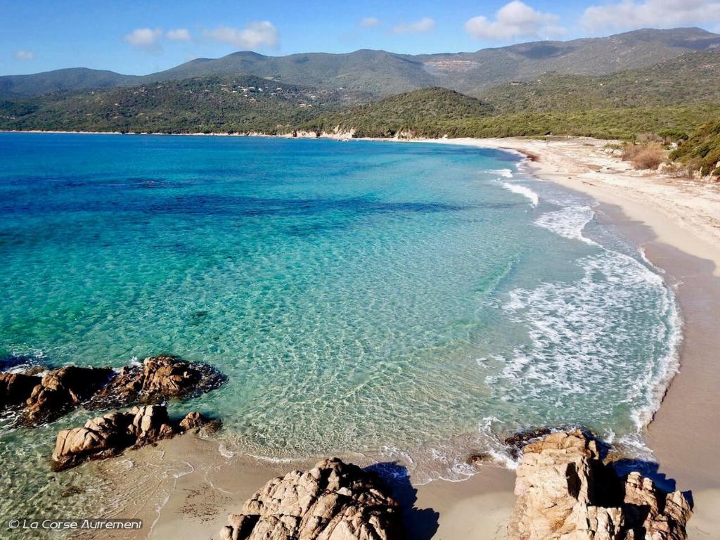 una vista aerea di una spiaggia con rocce e sull'oceano di Le Francorsicat a Serra di Ferro