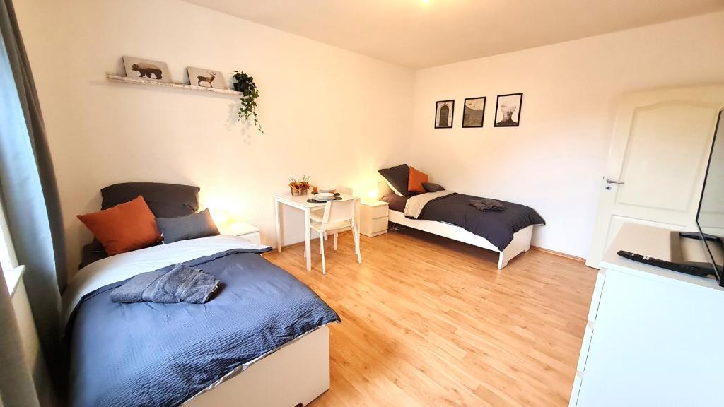 シュヴェーアテにあるModernes Apartment für 5 Personenのベッド2台とテーブルが備わる客室です。