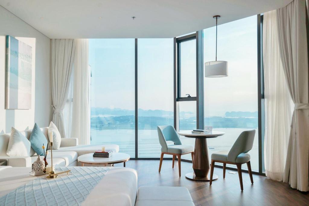 un salon avec un canapé, une table et des chaises dans l'établissement Luxury 5star Residence À La Carte HaLong Bay Floor 37, à Hạ Long