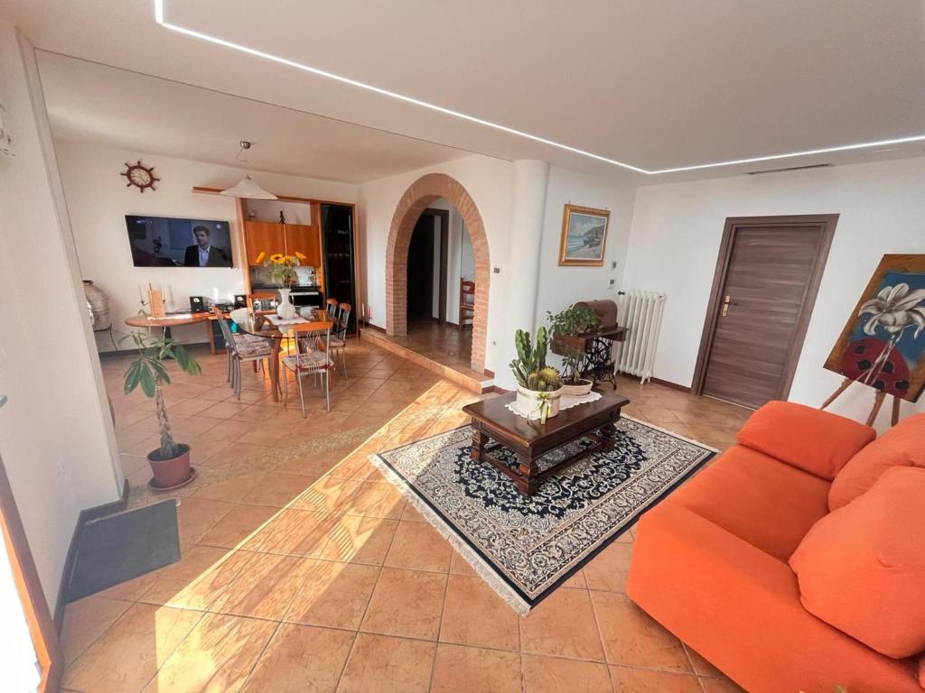 a living room with an orange couch and a table at Apartment Diva Canova Laguna Veneta in Codevigo