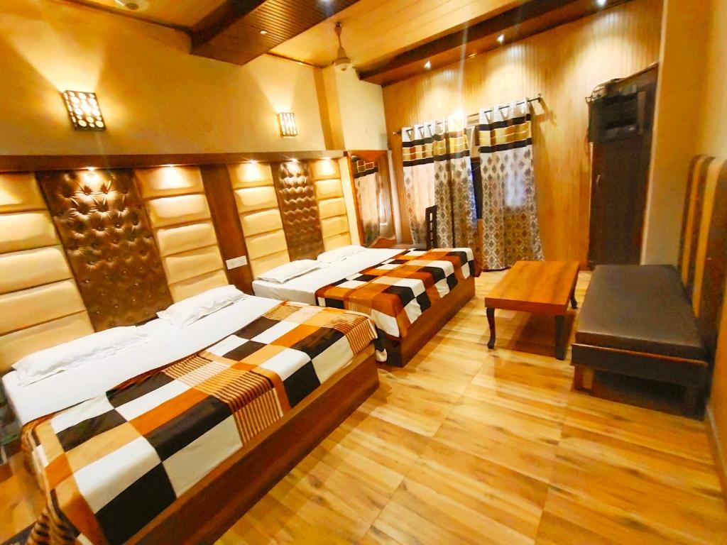 una camera con tre letti e un tavolo di Hotel Stay Revoli - Just Half k.m From Golden Temple ad Amritsar