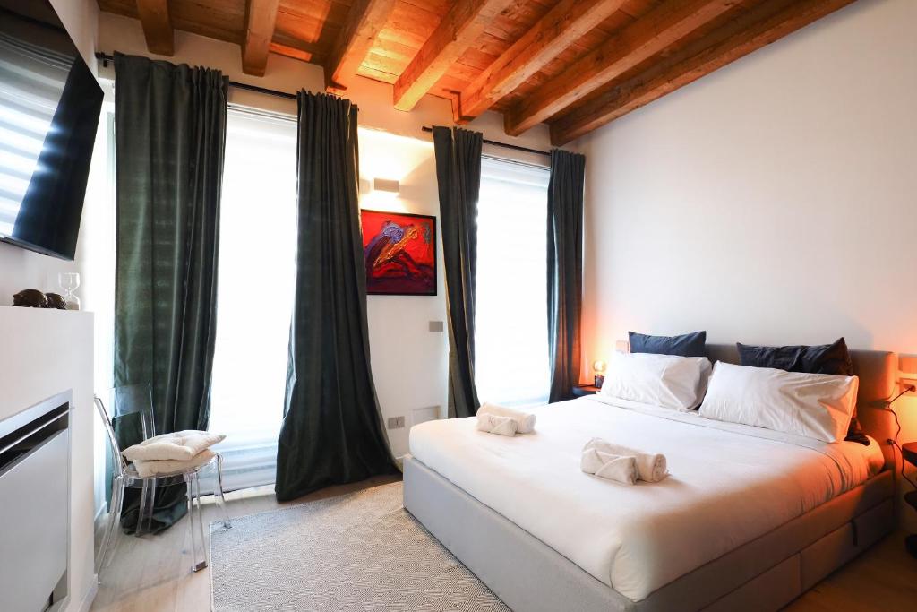 a bedroom with a large white bed in front of windows at Primopiano - Zumbini in Milan