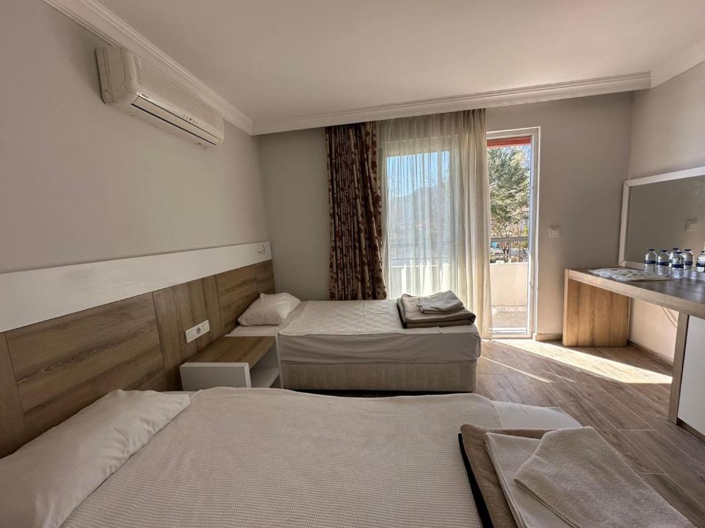 een hotelkamer met 2 bedden en een raam bij BELCAN Hotel in Beldibi