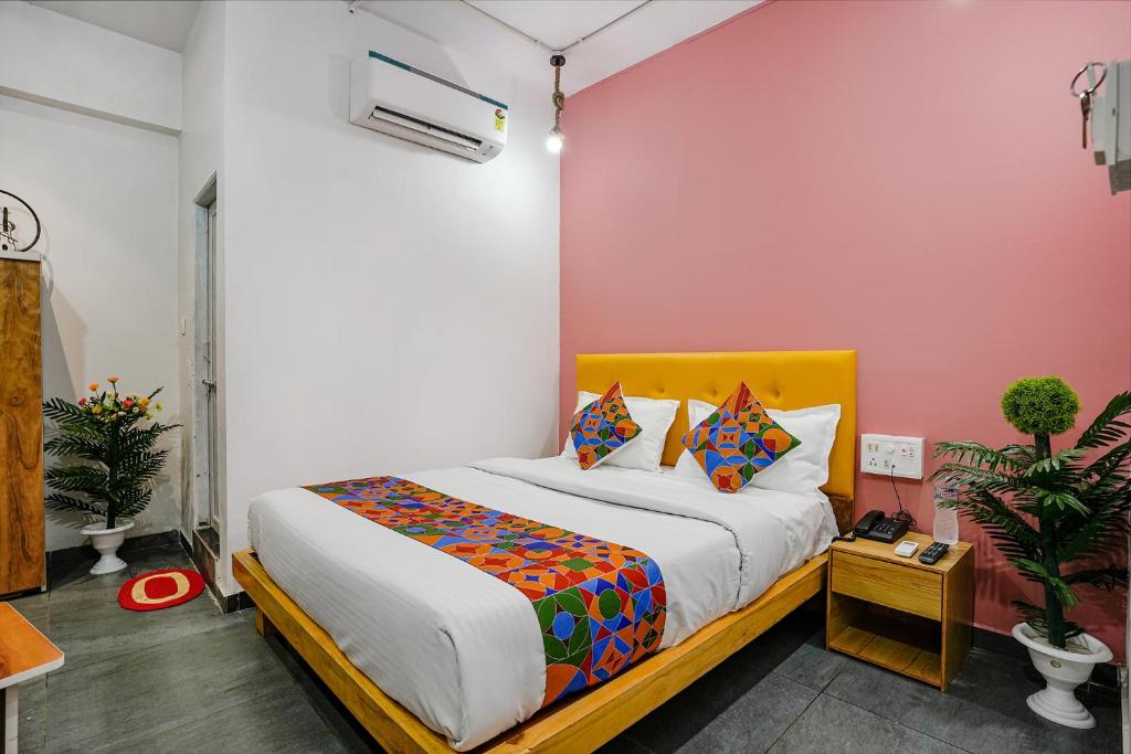 een slaapkamer met een bed met een geel hoofdeinde bij FabHotel Sky City in Surat