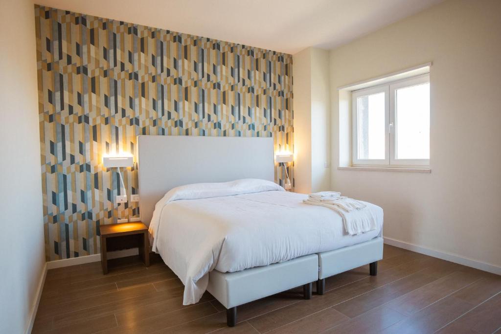 ein Schlafzimmer mit einem großen Bett und einem Fenster in der Unterkunft Tre cancelli rooms in Potenza