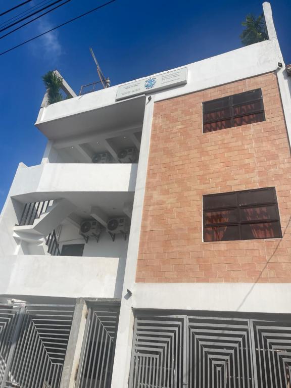 a brick and white building with two windows at Blue-Sky Wave in Antipolo