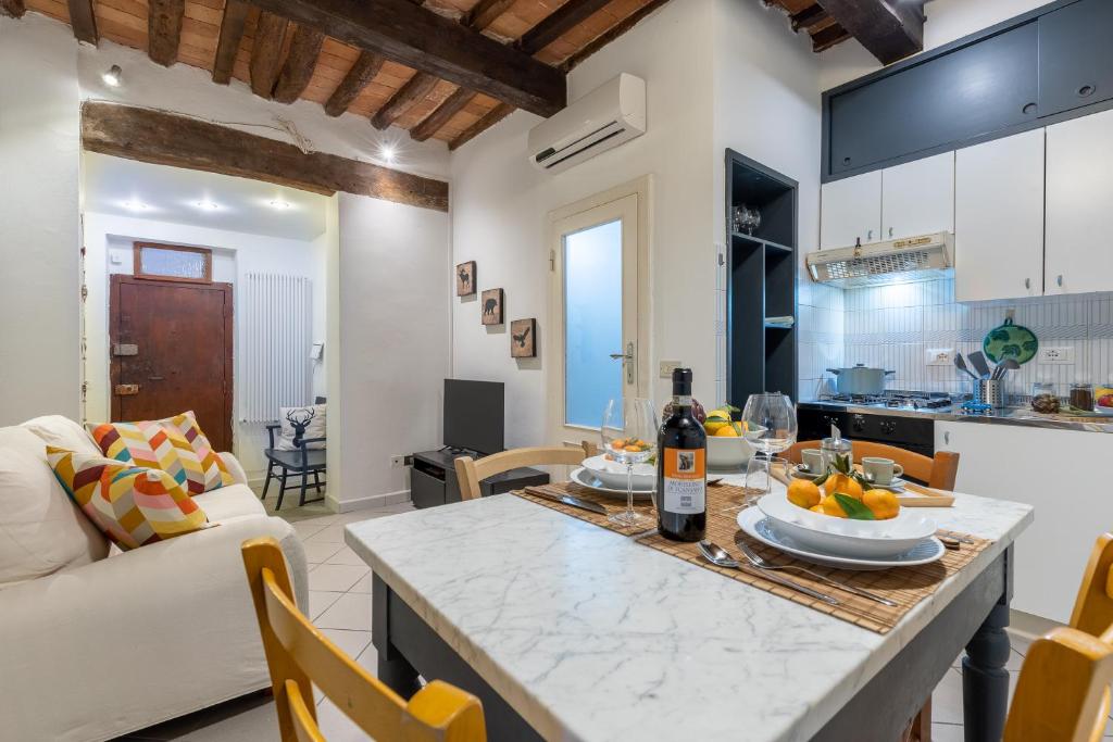 uma cozinha e sala de estar com uma mesa e um sofá em Piazza dei Cavalieri Confortable Apartment em Pisa