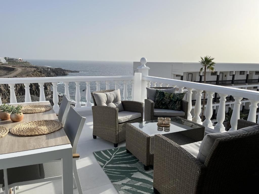 a balcony with chairs and tables and a view of the ocean at aguaviva experience premium apartment in Callao Salvaje