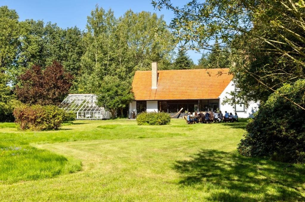 um grupo de pessoas sentadas em frente a uma casa em Stoksholmene13 em Svebølle