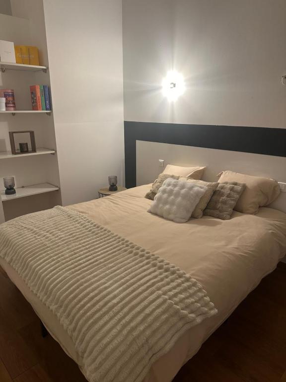 białe łóżko z poduszkami i lampką nad nim w obiekcie Loft de charme avec terrasse et jardin au Fort d’Asfeld w mieście Sedan