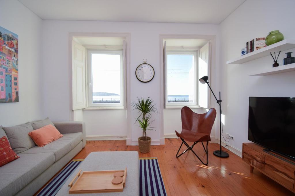 a living room with a couch and a tv at Casa Tejo in Cruz Quebrada