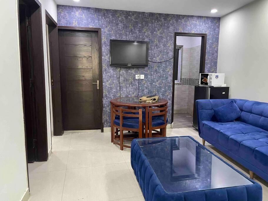 a living room with a blue couch and a table at 3 bed Luxurious Apartment DHA PH8 in Lahore