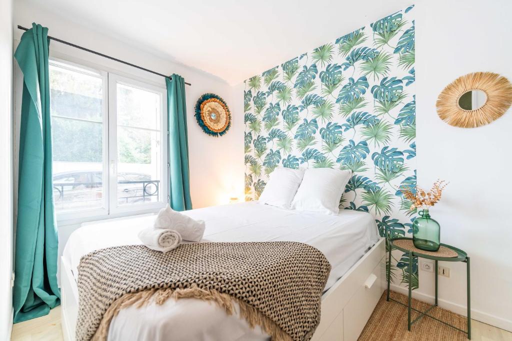 une chambre avec un lit avec un papier peint tropical dans l'établissement F2 coloré et confortable proche Disney+WIFI, à Bailly-Romainvilliers