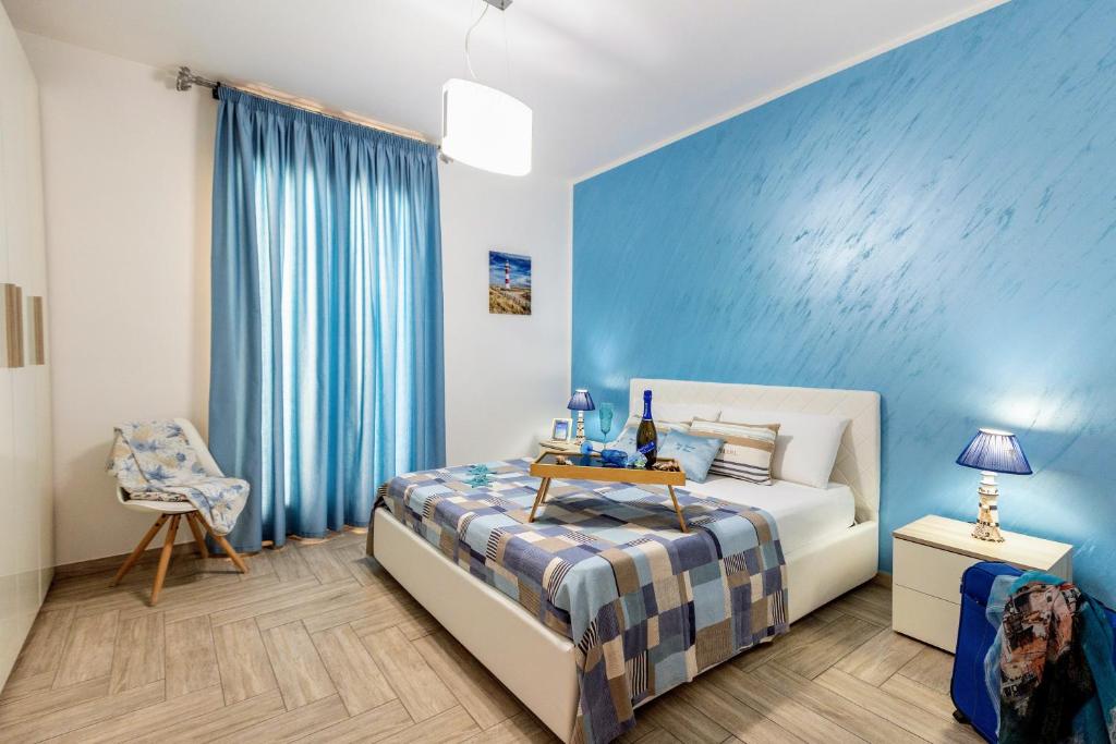 サン・ヴィート・ロ・カーポにあるCasa Vacanze Il Faro San Vito Lo Capo-Trapani-Sicilia Ovest Holiday Homeの青い壁のベッドルーム1室(ベッド1台付)